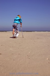 A girl with a broken leg, on crutches, looks longingly at the waves on a beach in South Africa on our trip around the world.